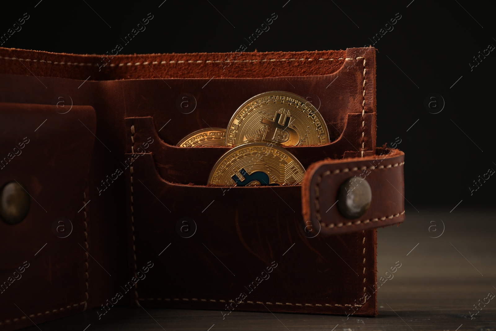 Cryptocurrency. Bitcoins in wallet on wooden background, closeup Photo of Cryptocurrency. Bitcoins in wallet on wooden background, closeup