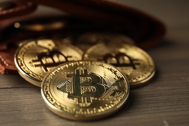 Photo of Cryptocurrency. Bitcoins and wallet on wooden background, closeup