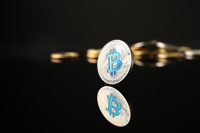 Photo of Cryptocurrency. Bitcoins on black mirror surface, closeup. Space for text