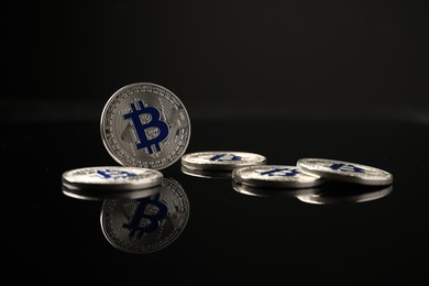 Photo of Cryptocurrency. Bitcoins on black mirror surface, closeup
