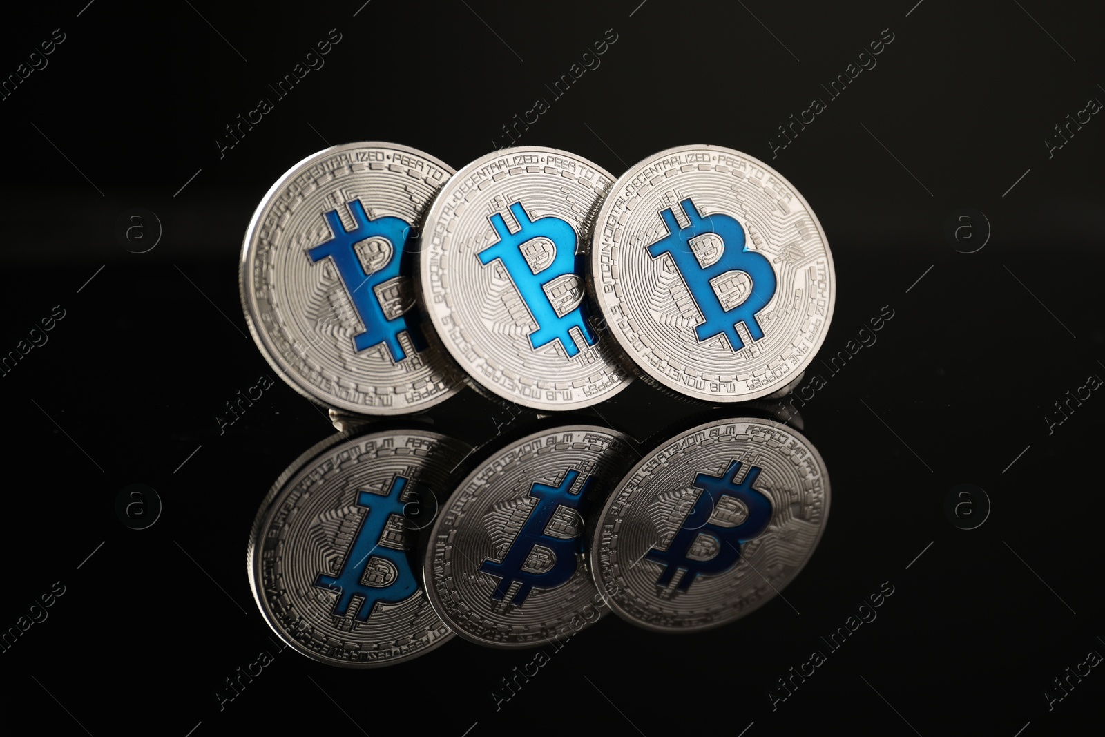 Cryptocurrency. Bitcoins on black mirror surface, closeup Photo of Cryptocurrency. Bitcoins on black mirror surface, closeup