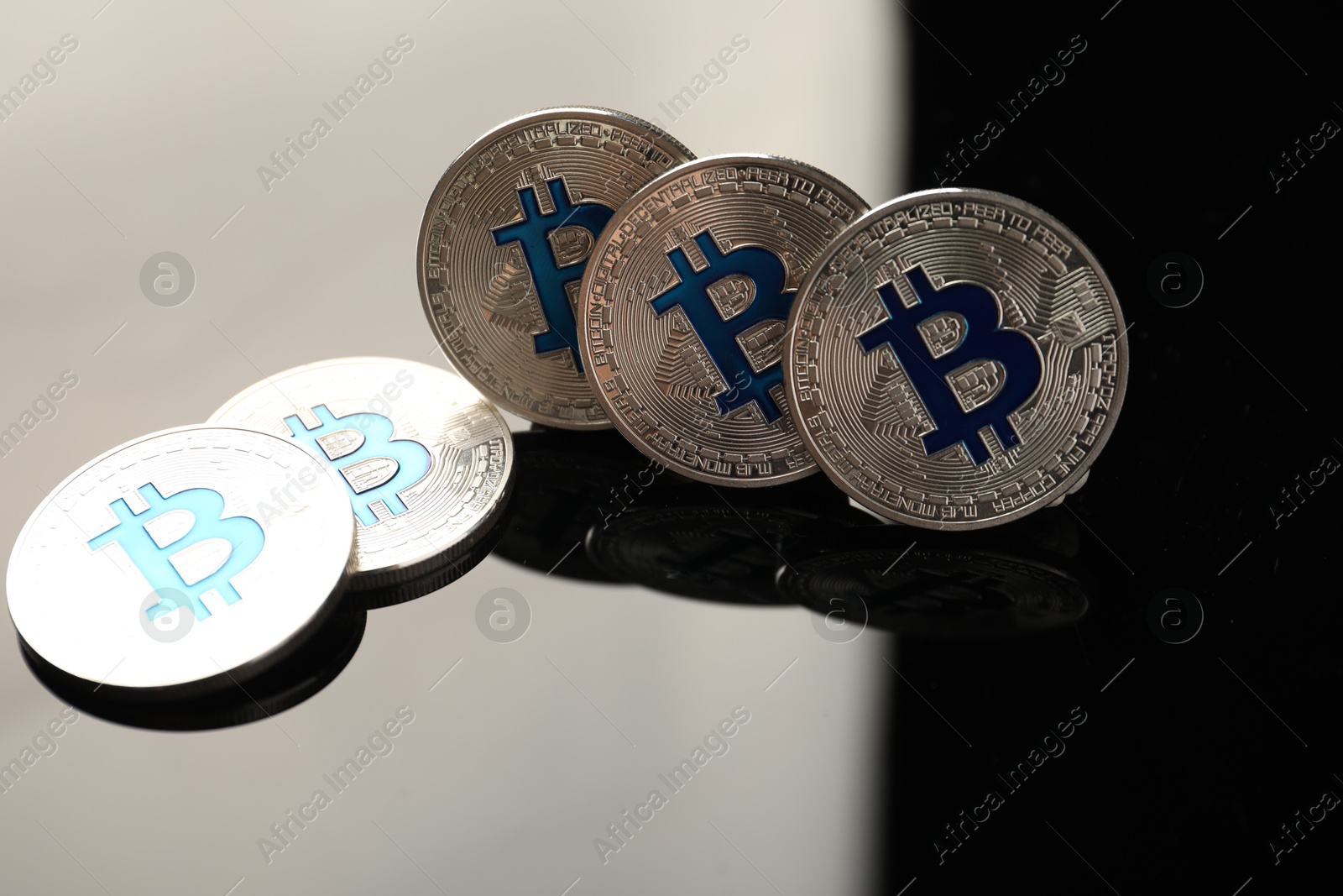 Cryptocurrency. Bitcoins on black mirror surface, closeup Photo of Cryptocurrency. Bitcoins on black mirror surface, closeup
