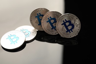 Photo of Cryptocurrency. Bitcoins on black mirror surface, closeup