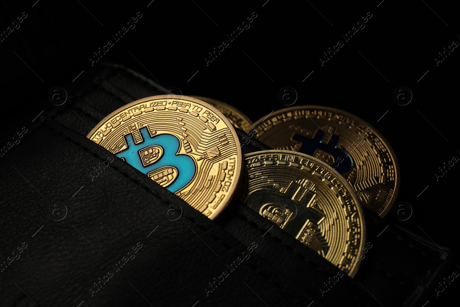 Cryptocurrency. Bitcoins in wallet on dark background, closeup Photo of Cryptocurrency. Bitcoins in wallet on dark background, closeup
