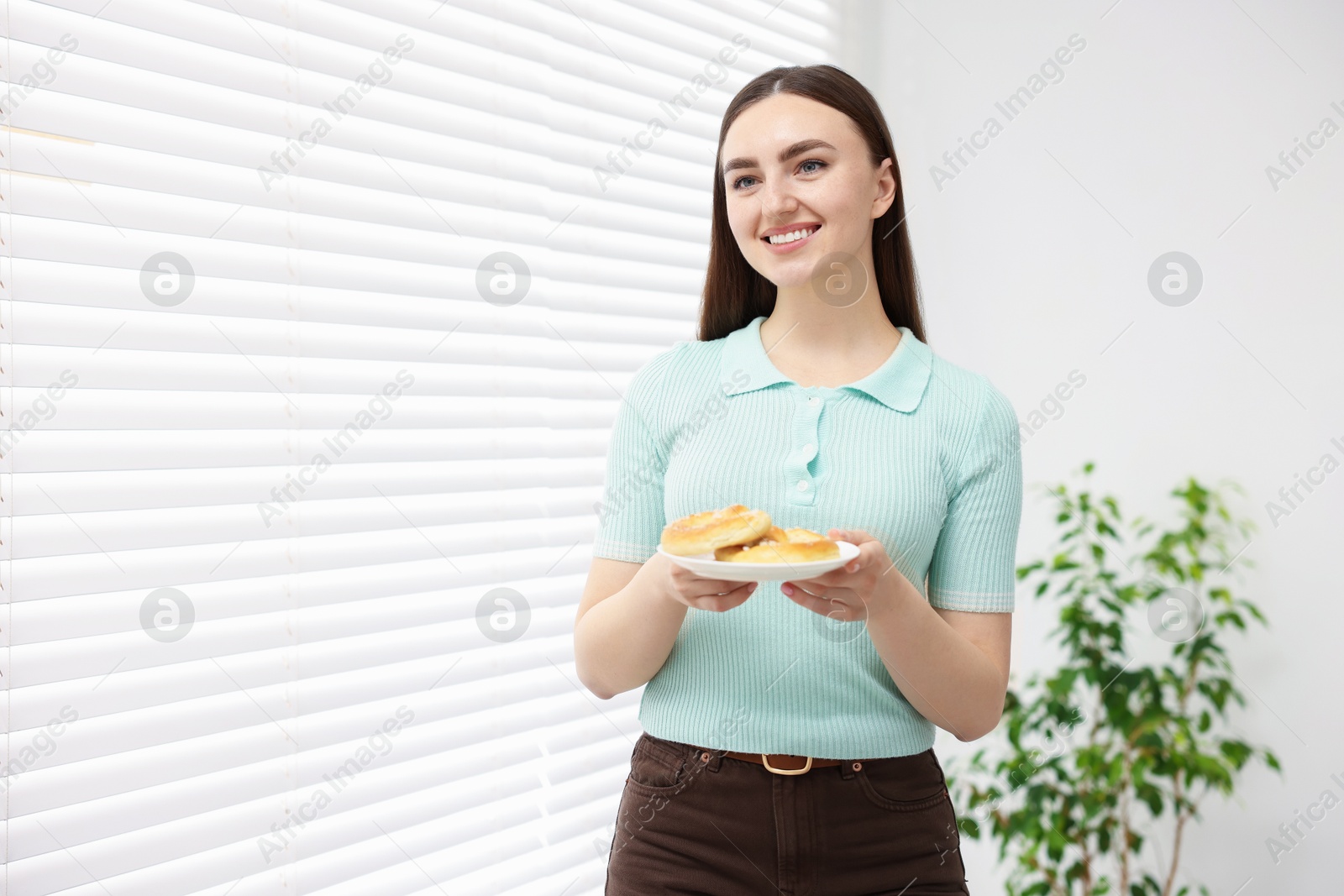 Gluten free diet. Young woman holding tasty pretzels indoors, space for text Photo of Gluten free diet. Young woman holding tasty pretzels indoors, space for text