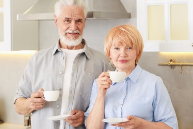 Photo of Lovely senior couple with cups of coffee in kitchen