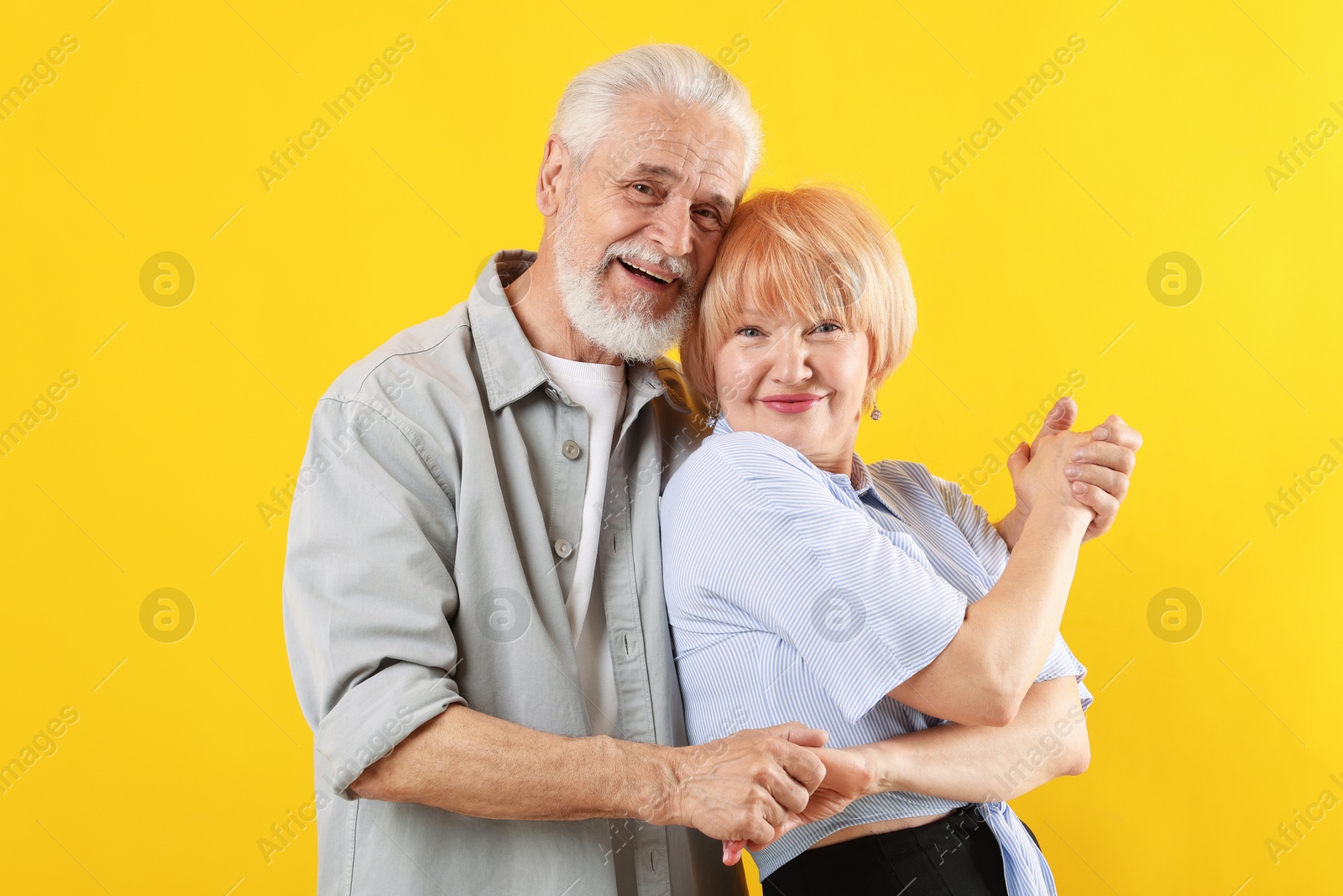 Lovely senior couple together on yellow background Photo of Lovely senior couple together on yellow background