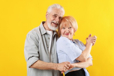 Photo of Lovely senior couple together on yellow background
