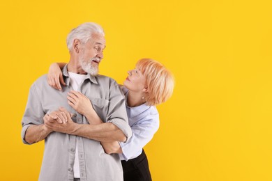 Photo of Lovely senior couple together on yellow background, space for text
