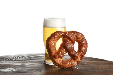 Photo of Tasty pretzel and glass of beer on wooden table against white background