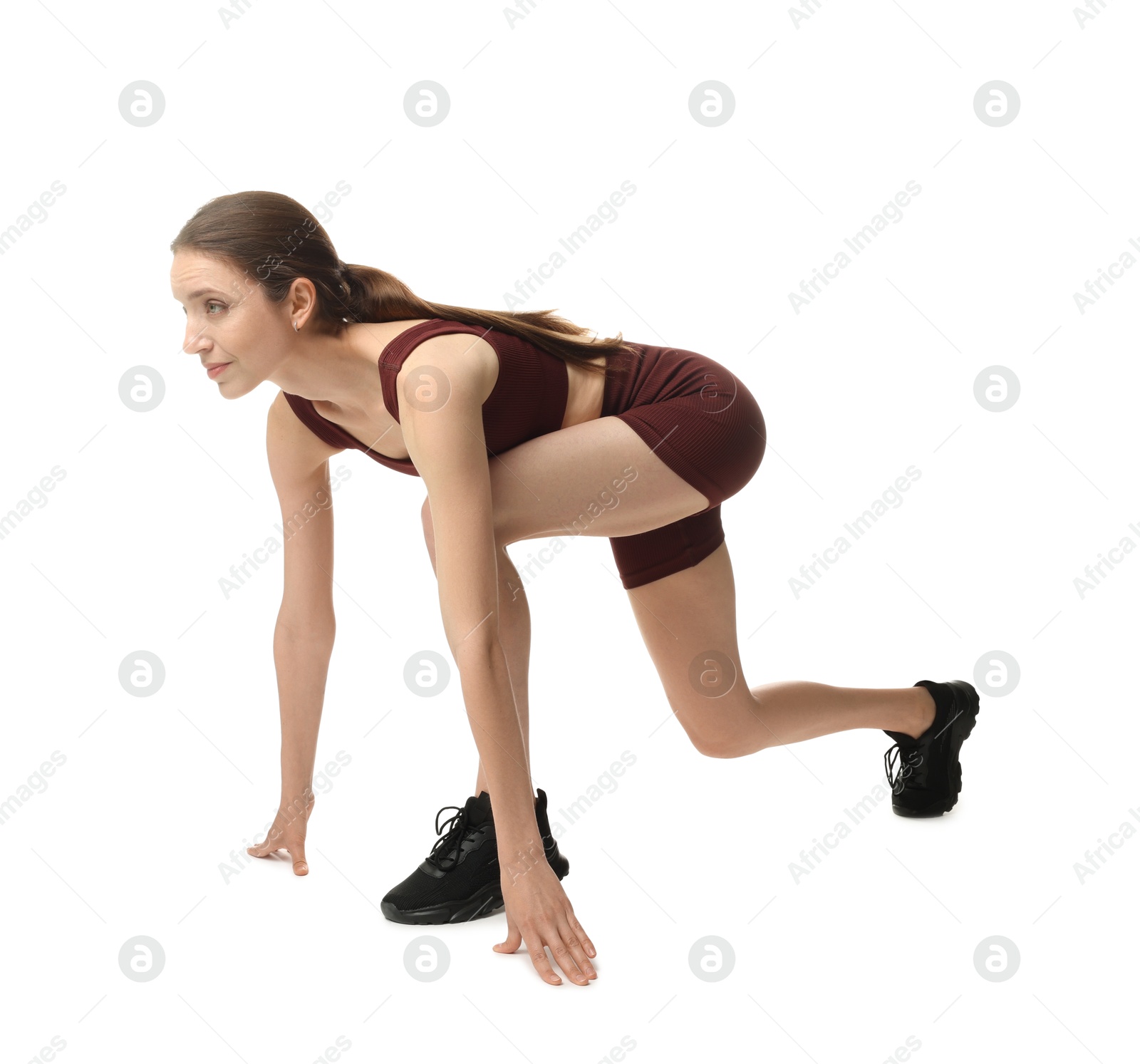 Runner in starting position on white background Photo of Runner in starting position on white background