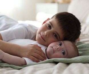 Photo of Cute little brothers on bed at home