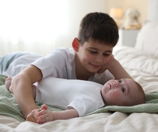 Photo of Cute little brothers on bed at home