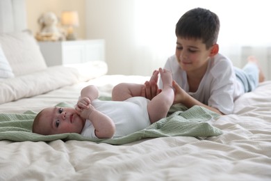 Photo of Cute little brothers on bed at home