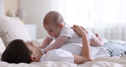 Photo of Cute little brothers on bed at home