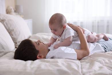 Photo of Cute little brothers on bed at home