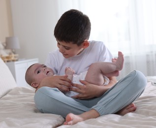 Photo of Cute little brothers on bed at home