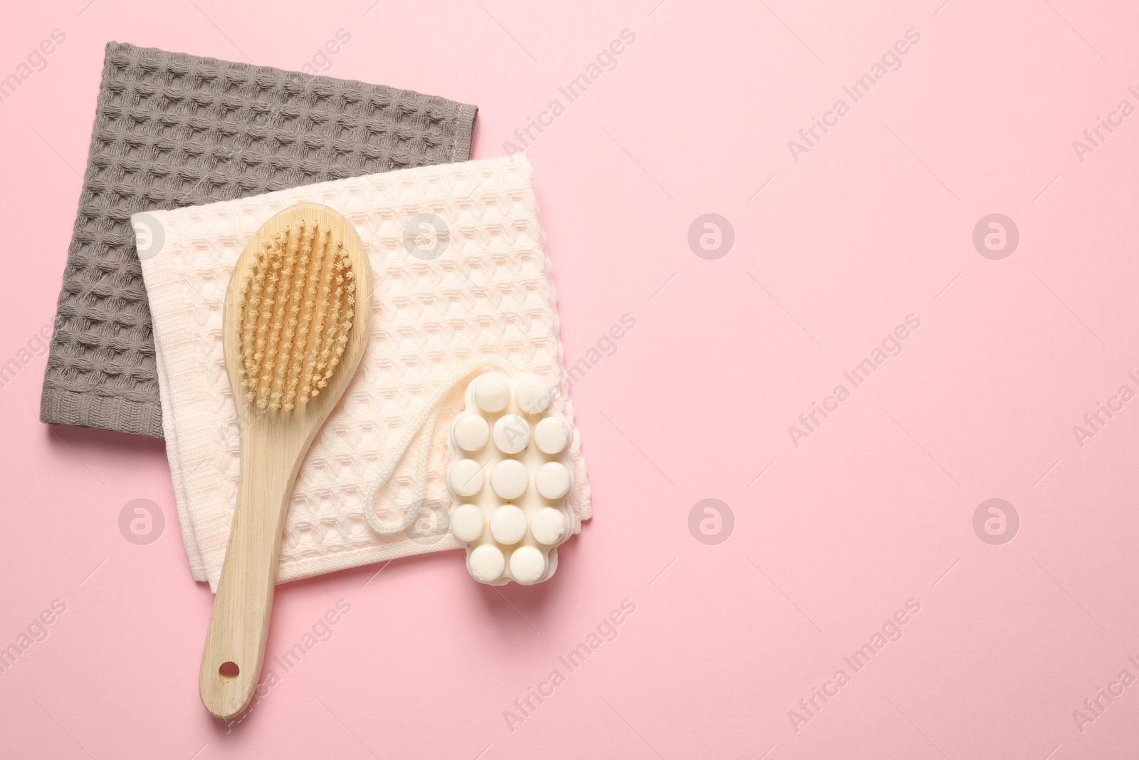 Clean waffle towels, soap and brush on pink background, top view. Space for text Photo of Clean waffle towels, soap and brush on pink background, top view. Space for text