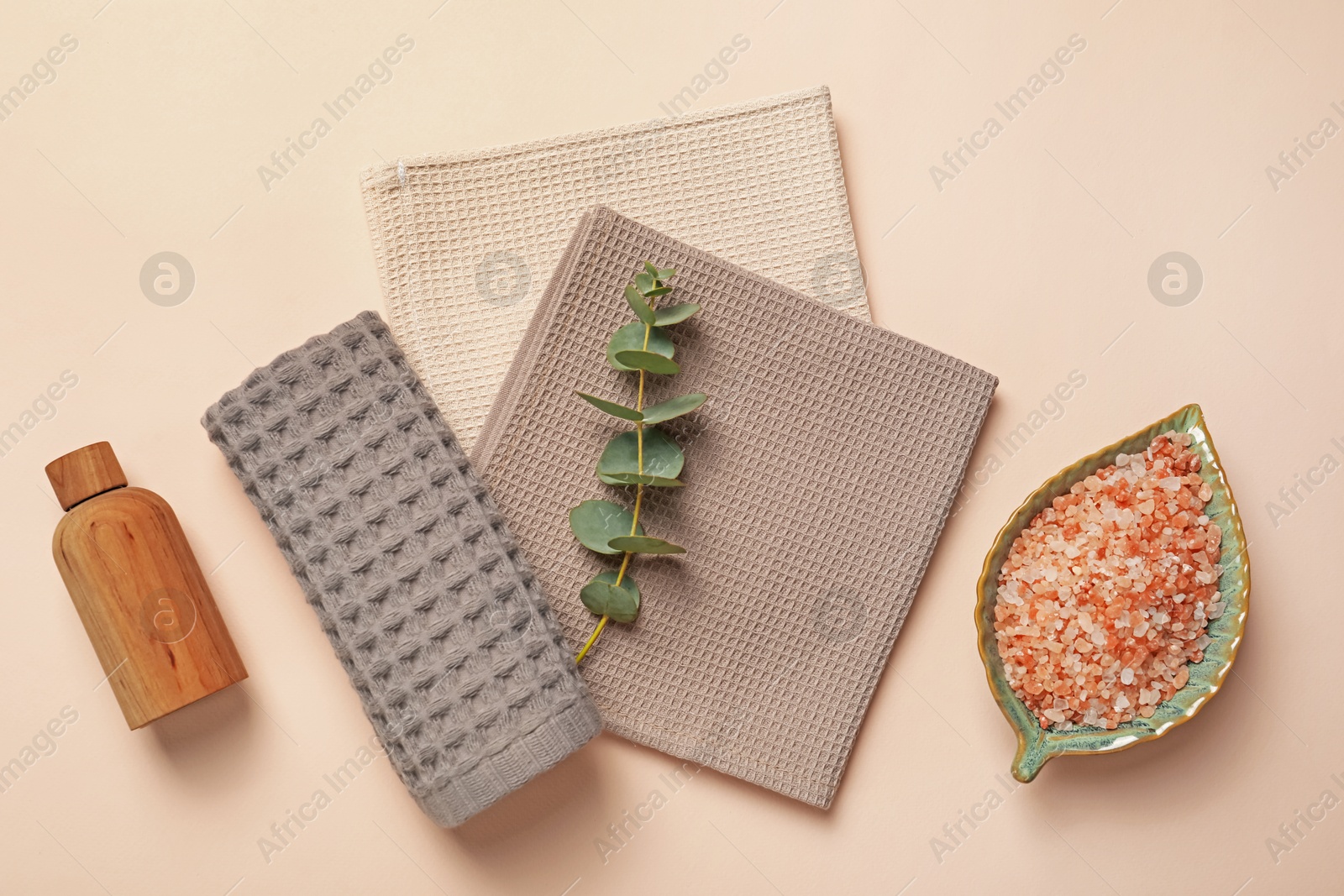Clean waffle towels, cosmetic products and eucalyptus branch on beige background, flat lay Photo of Clean waffle towels, cosmetic products and eucalyptus branch on beige background, flat lay