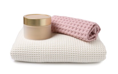 Photo of Clean waffle towels and cosmetic product isolated on white