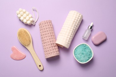 Photo of Clean waffle towels, cosmetic products and brush on violet background, flat lay