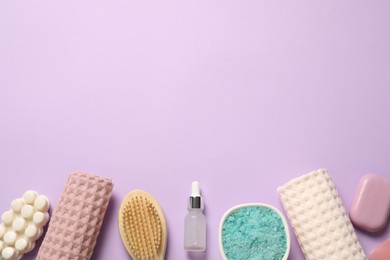 Photo of Clean waffle towels, cosmetic products and brush on violet background, flat lay. Space for text