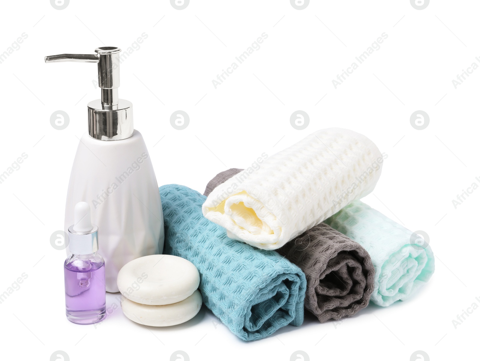Clean waffle towels, cosmetic products and spa stones isolated on white Photo of Clean waffle towels, cosmetic products and spa stones isolated on white