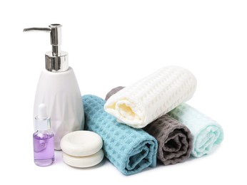 Photo of Clean waffle towels, cosmetic products and spa stones isolated on white