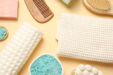 Photo of Clean waffle towels, cosmetic products and supplies on beige background, flat lay
