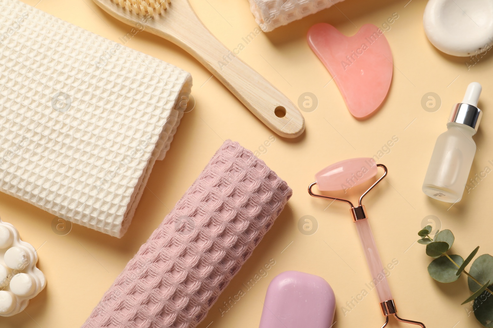 Clean waffle towels, cosmetic products and supplies on beige background, flat lay Photo of Clean waffle towels, cosmetic products and supplies on beige background, flat lay