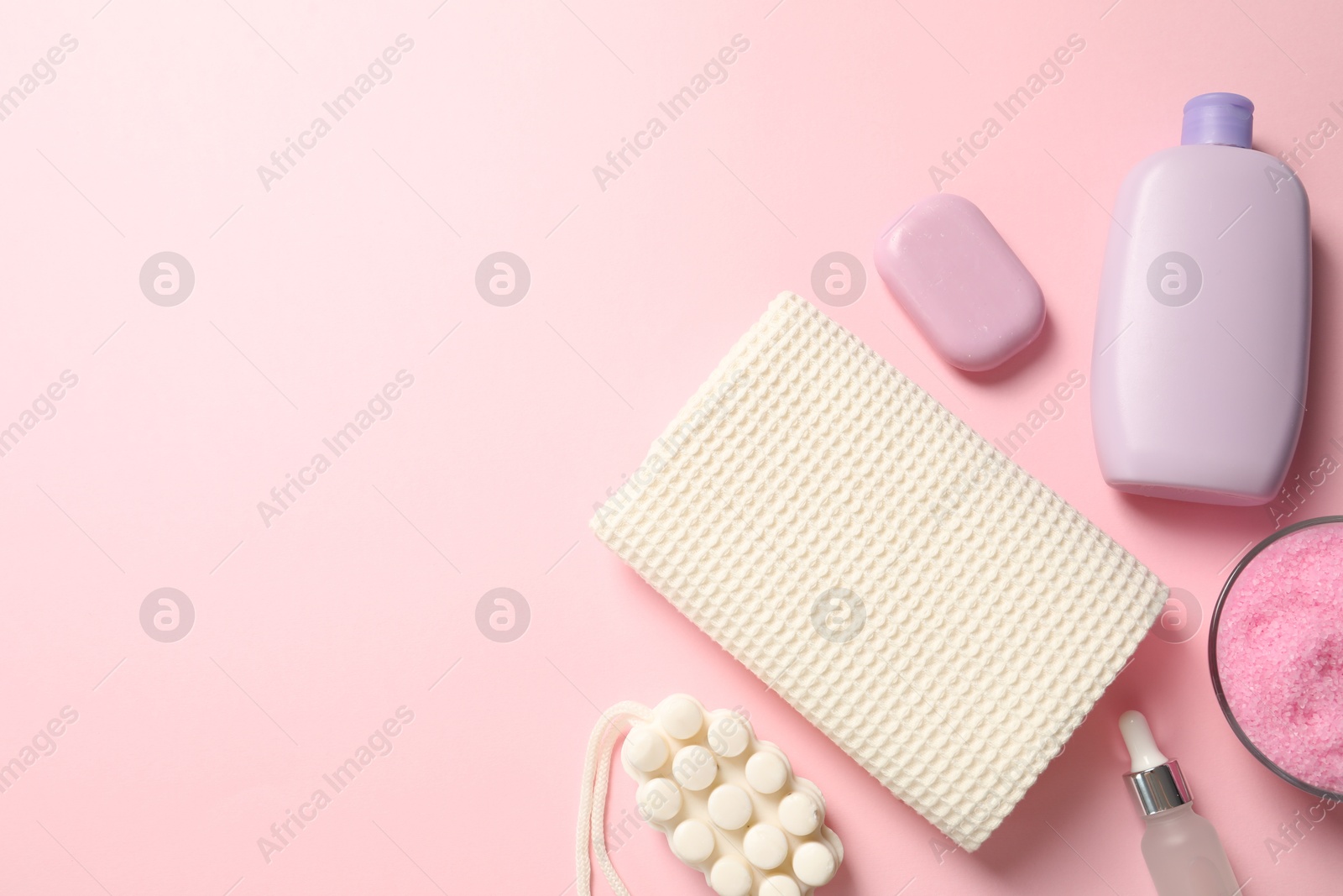 Clean waffle towel and cosmetic products on pink background, flat lay. Space for text Photo of Clean waffle towel and cosmetic products on pink background, flat lay. Space for text