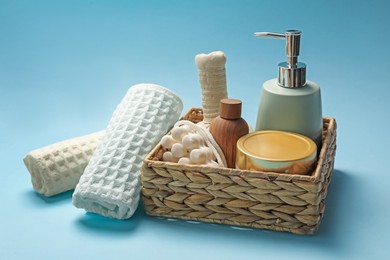 Photo of Clean waffle towels and cosmetic products on light blue background
