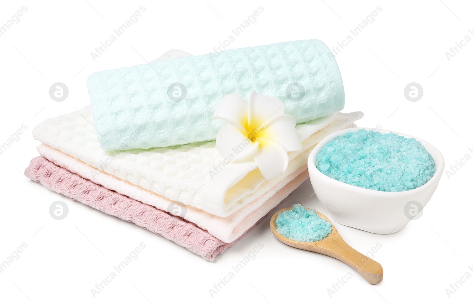 Clean waffle towels, sea salt and plumeria flower isolated on white Photo of Clean waffle towels, sea salt and plumeria flower isolated on white