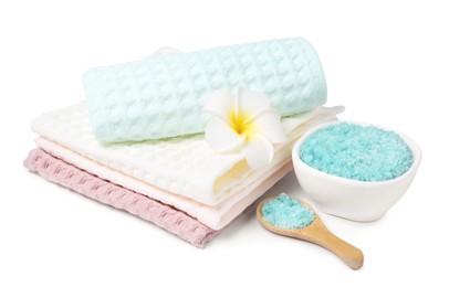 Photo of Clean waffle towels, sea salt and plumeria flower isolated on white