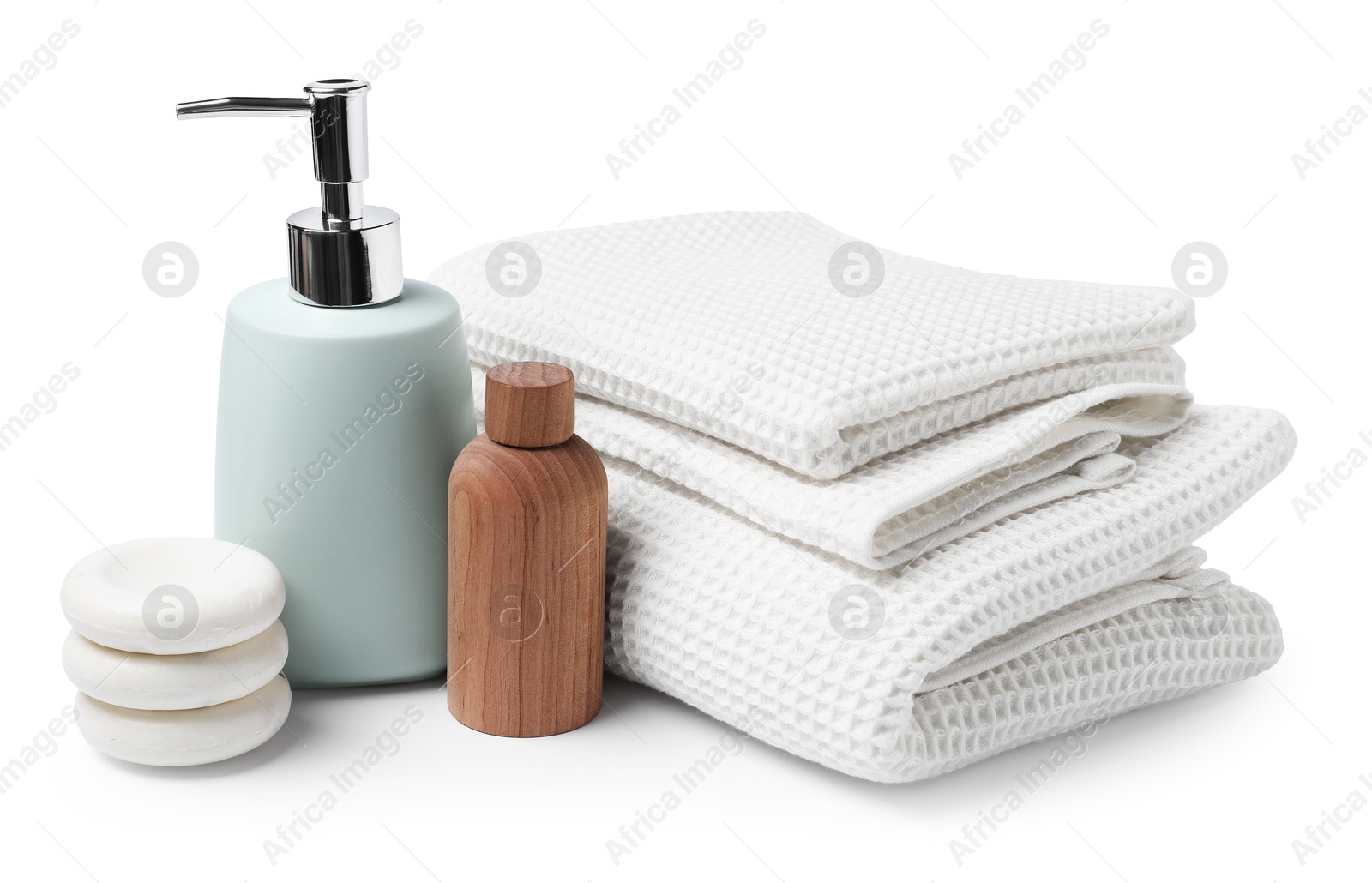 Clean waffle towels, cosmetic products and spa stones isolated on white Photo of Clean waffle towels, cosmetic products and spa stones isolated on white