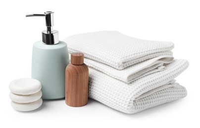 Photo of Clean waffle towels, cosmetic products and spa stones isolated on white