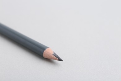 Photo of Grey eyebrow pencil on light background, closeup. Space for text