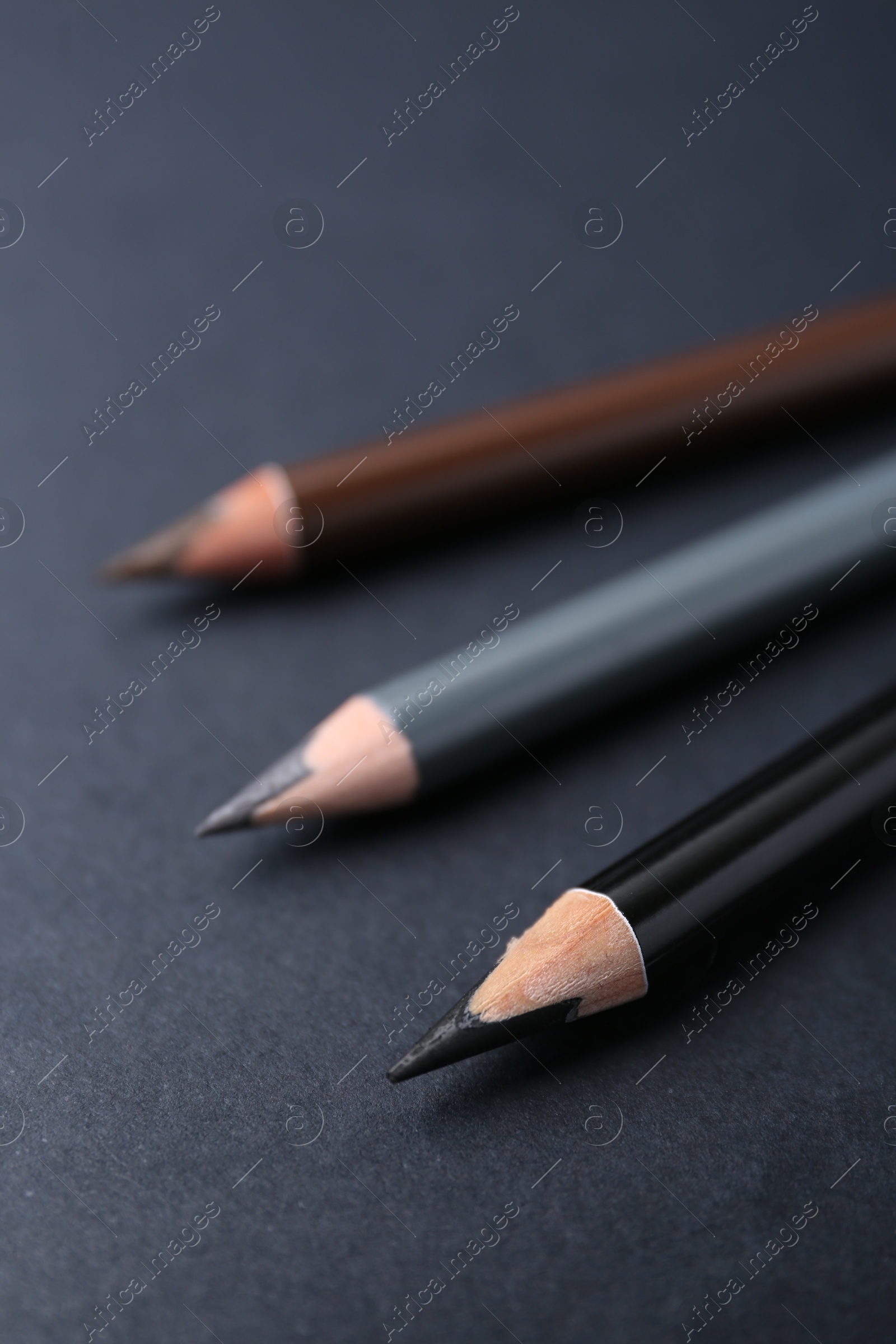 Three different eyebrow pencils on dark background, closeup Photo of Three different eyebrow pencils on dark background, closeup