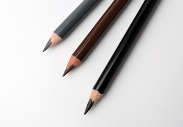 Photo of Three different eyebrow pencils on white background, top view