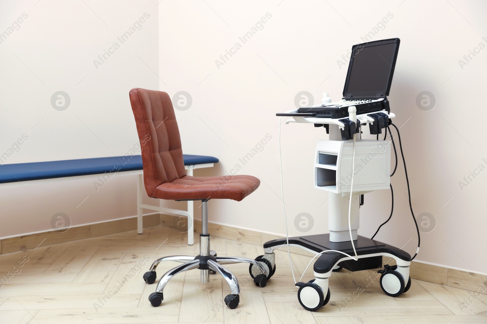 Modern ultrasound machine, chair and examination bed in clinic Photo of Modern ultrasound machine, chair and examination bed in clinic