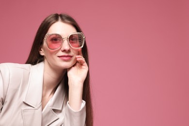 Photo of Fashionable portrait of beautiful woman in stylish outfit on pink background. Space for text