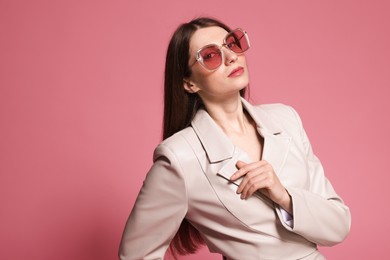 Photo of Fashionable portrait of beautiful woman in stylish outfit on pink background