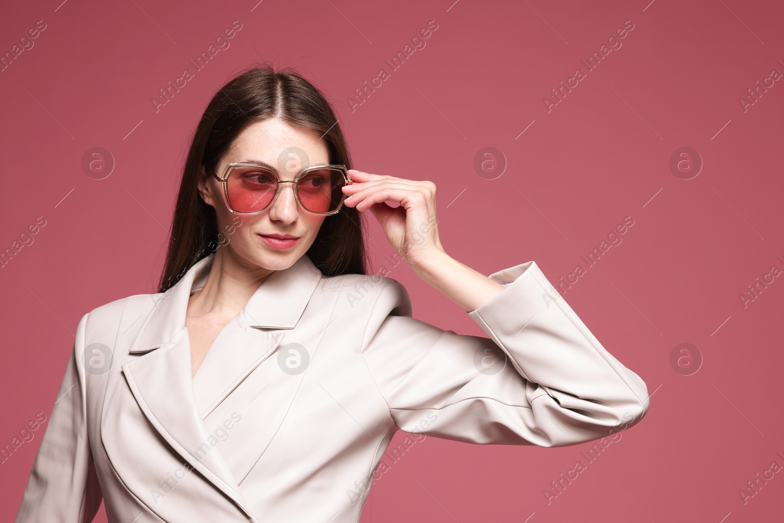 Fashionable portrait of beautiful woman in stylish outfit on pink background Photo of Fashionable portrait of beautiful woman in stylish outfit on pink background
