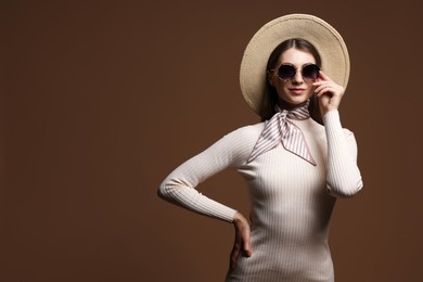 Photo of Fashionable portrait of beautiful woman in stylish outfit on brown background. Space for text