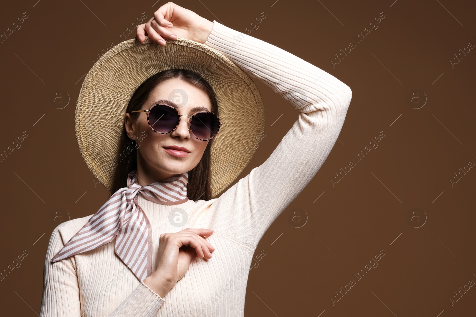 Fashionable portrait of beautiful woman in stylish outfit on brown background Photo of Fashionable portrait of beautiful woman in stylish outfit on brown background