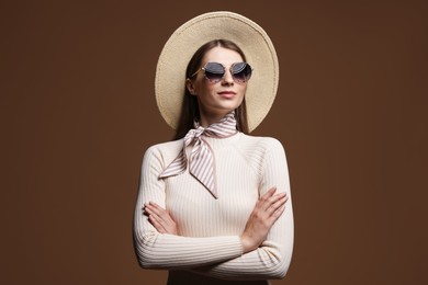 Photo of Fashionable portrait of beautiful woman in stylish outfit on brown background