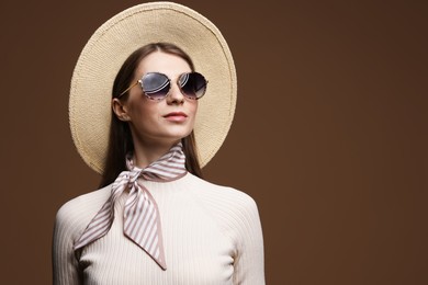 Photo of Fashionable portrait of beautiful woman in stylish outfit on brown background. Space for text