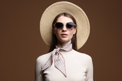 Photo of Fashionable portrait of beautiful woman in stylish outfit on brown background