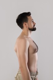 Photo of Handsome man in pants posing on grey background