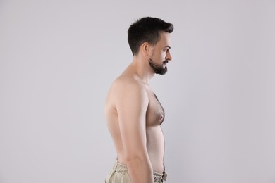 Photo of Man with incorrect posture posing on grey background